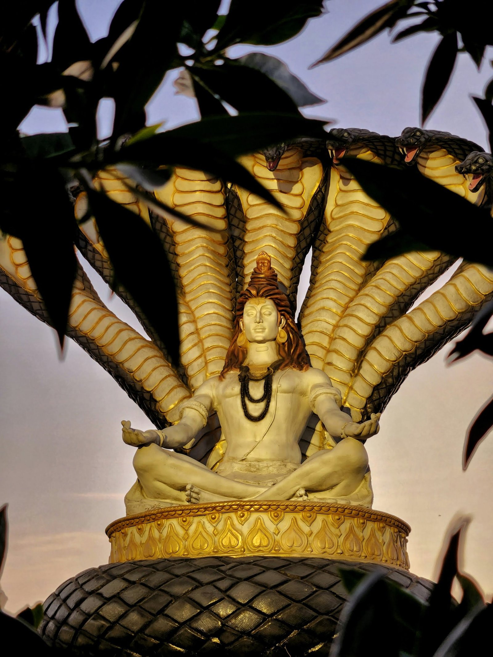 a statue of a woman sitting on top of a tree