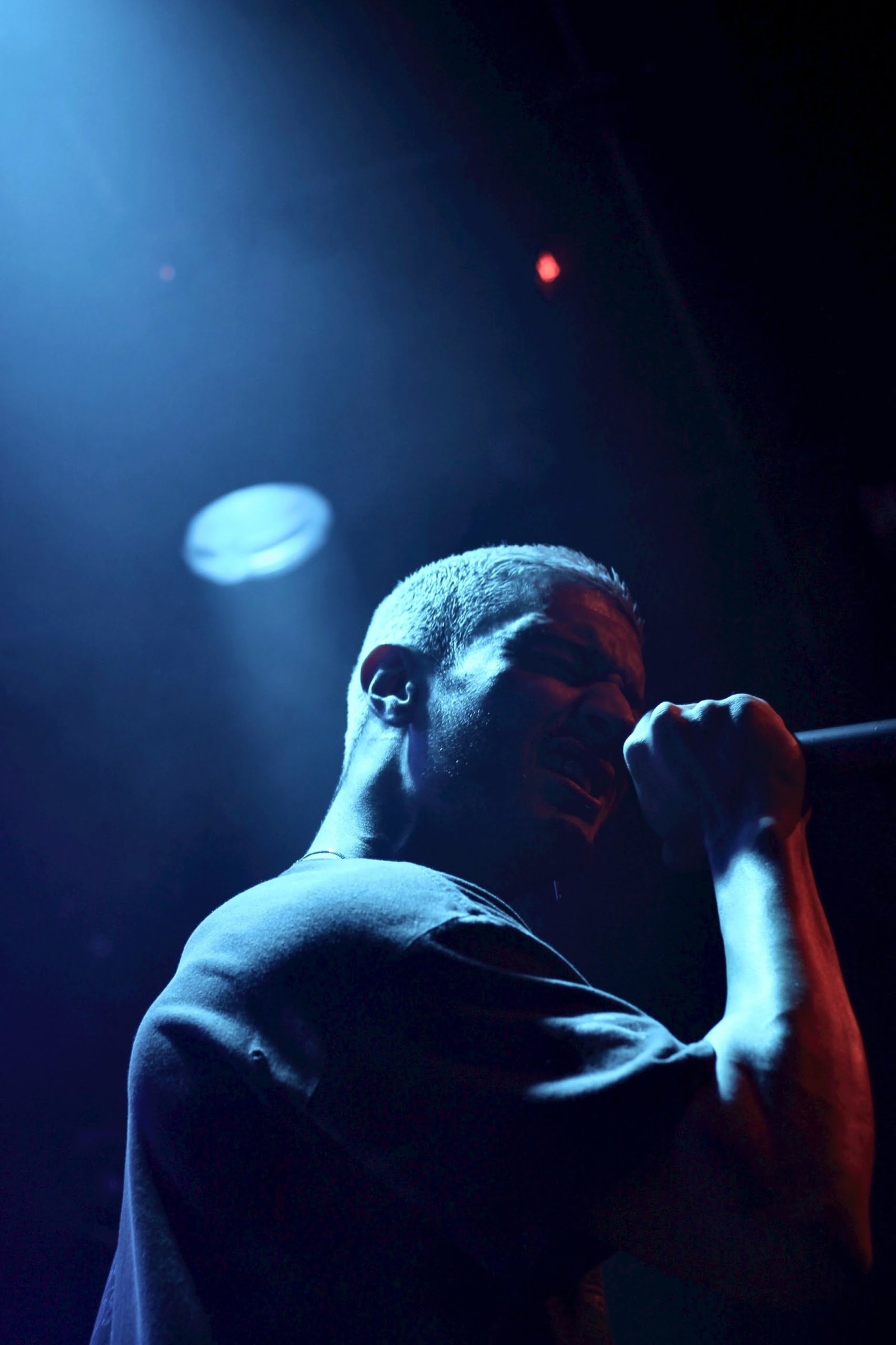 man holding microphone performing on stage